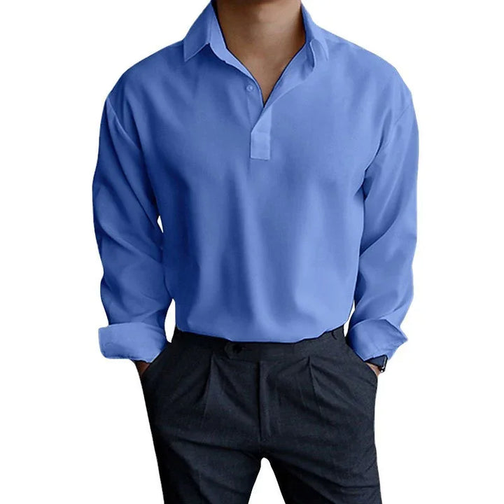 Man wearing blue long-sleeve casual shirt with button collar and black pleated trousers