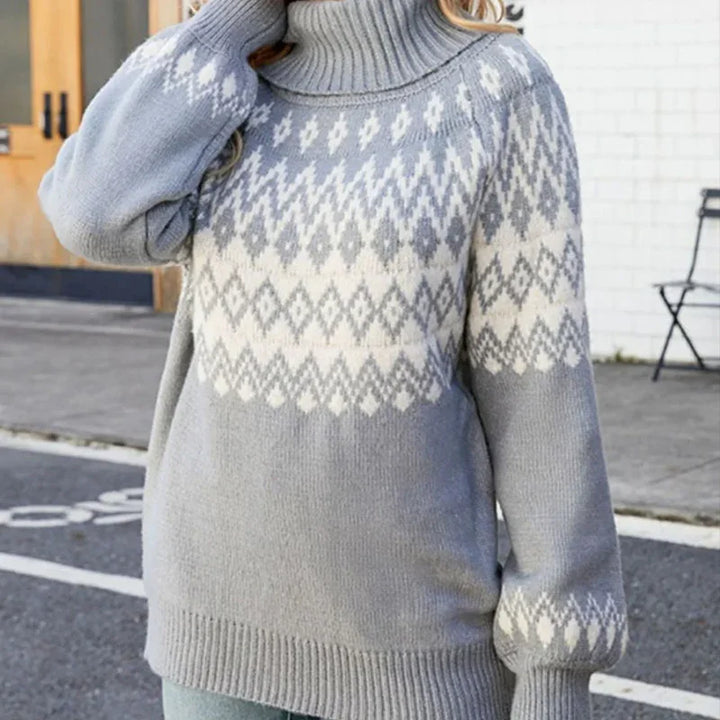 Woman wearing a gray and white patterned turtleneck knit sweater with puff sleeves outdoors