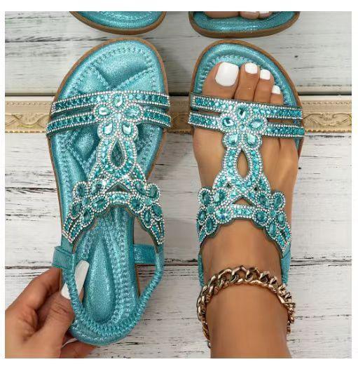 Turquoise embellished sandals with rhinestones, worn on foot with white nail polish and gold anklet