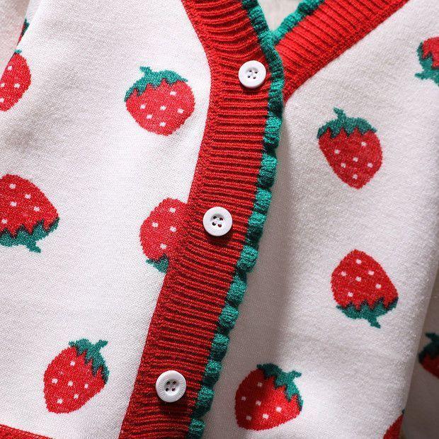 White knit cardigan with red strawberry patterns and red-green ribbed trim with white buttons