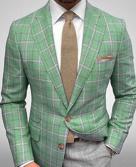 Man wearing green plaid blazer with white shirt, tan textured tie, and beige pocket square