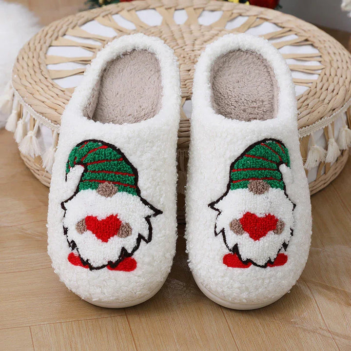 Cozy white fleece slippers with embroidered Christmas gnome holding red heart on wooden floor