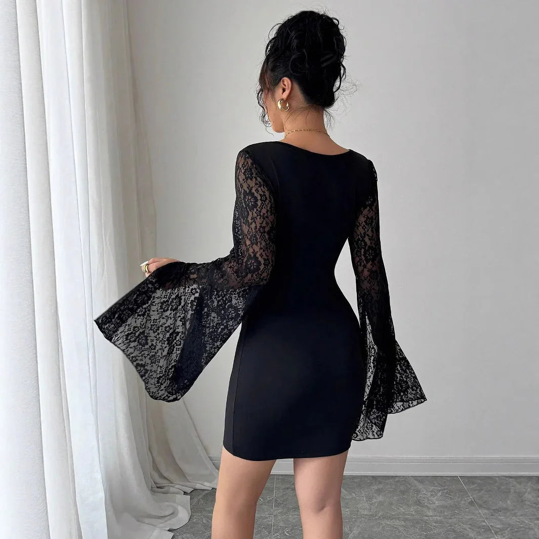 Woman wearing a black lace sleeve bodycon dress standing by white curtains in a minimalist room