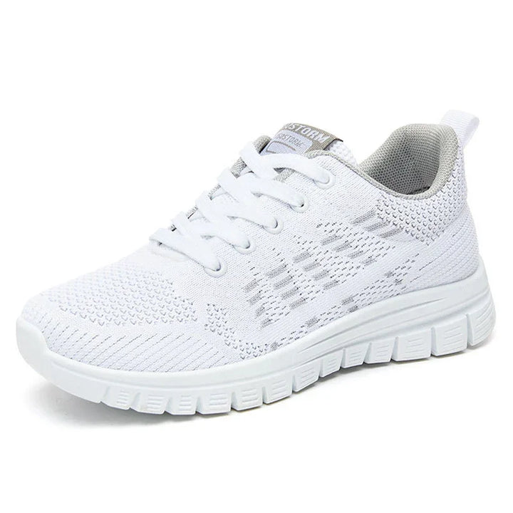 White breathable knit running shoe with cushioned sole and white laces on white background