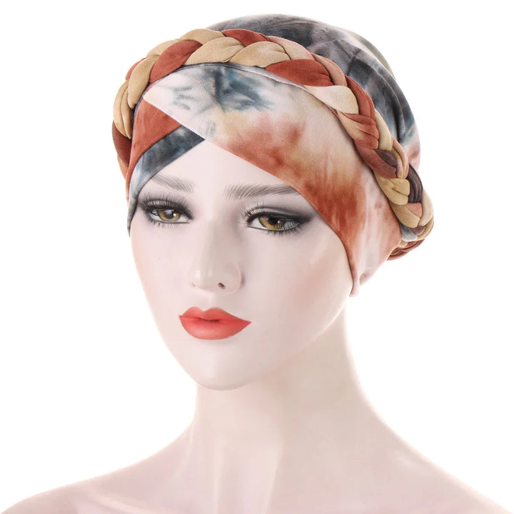 Woman's head with tie-dye turban headscarf featuring braided detail in brown, beige, and rust tones