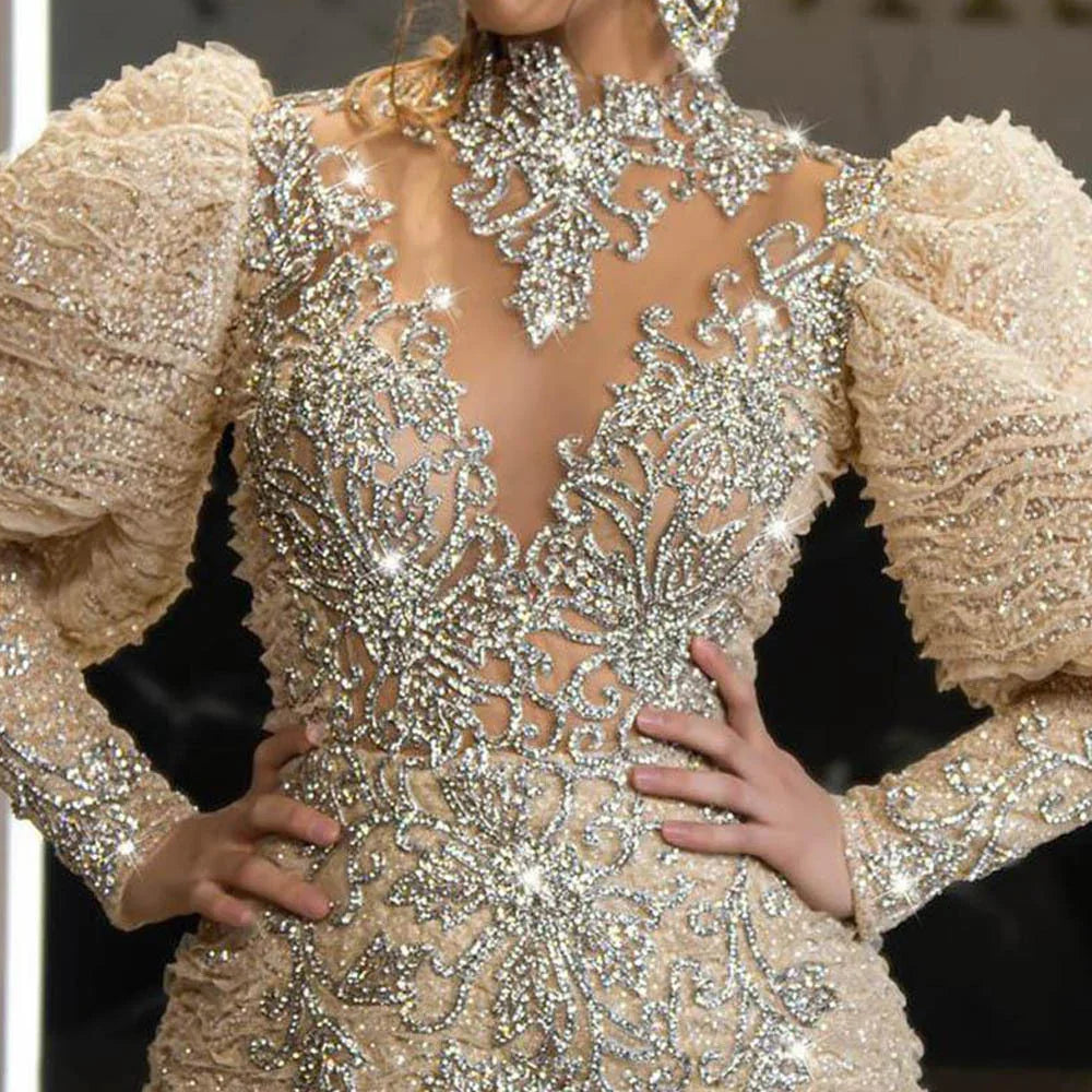 Close-up of an elegant beige gown with puffed sleeves and intricate sparkling rhinestone embroidery