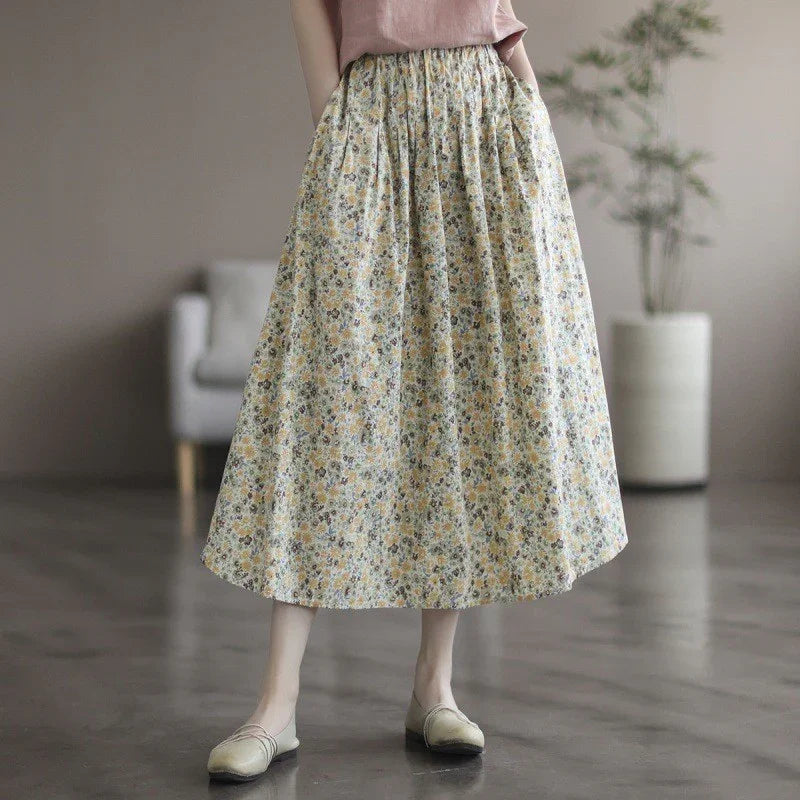 Woman wearing a floral midi skirt with elastic waist and beige flats in a modern indoor setting