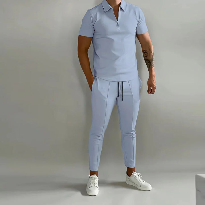 Man wearing light blue short sleeve zipper polo and matching slim pants with white sneakers