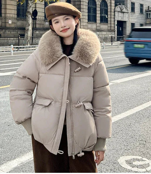 Woman wearing beige puffer jacket with large fur collar and brown beret on city street