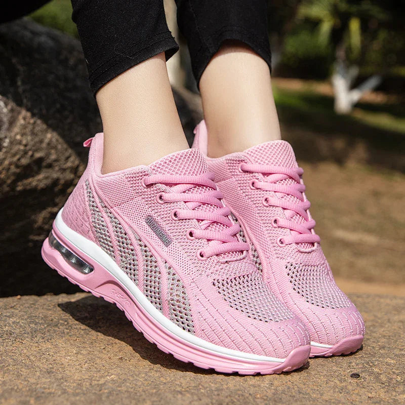 Close-up of pink breathable mesh running shoes with air cushion soles worn outdoors