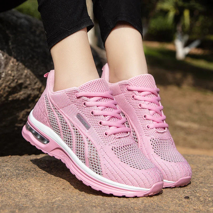 Close-up of pink breathable mesh running shoes with air cushion soles worn outdoors