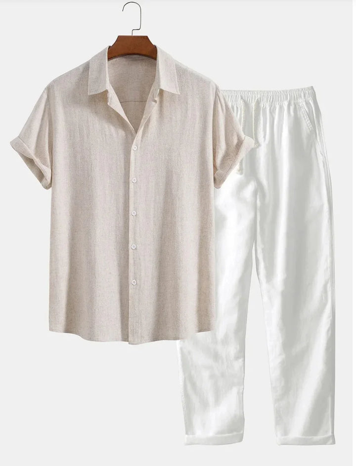 Beige short-sleeve button-up shirt on hanger with white elastic-waist pants on white background