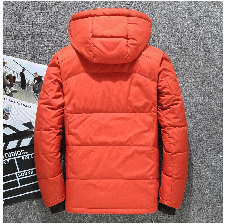 Back view of bright orange puffer jacket with hood on gray carpet background