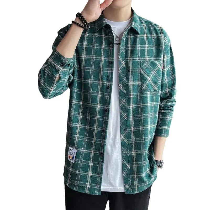 Man wearing green and white plaid flannel shirt over white t-shirt with black pants and accessories