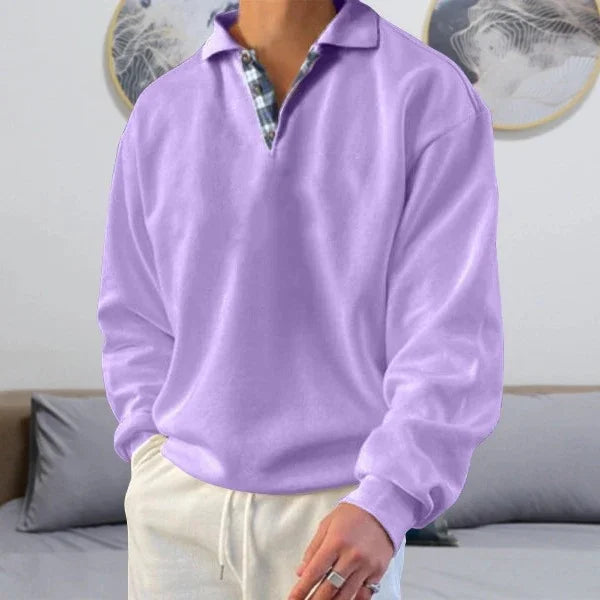 Man wearing casual lavender long-sleeve polo shirt with checkered collar detail in modern living room