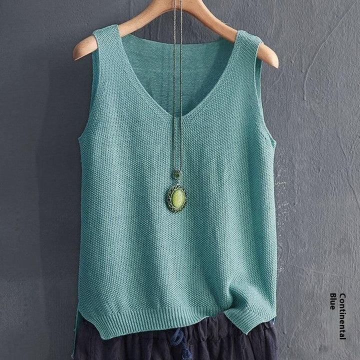 Light blue sleeveless knitted top with V-neck and pendant necklace hanging on wooden hanger