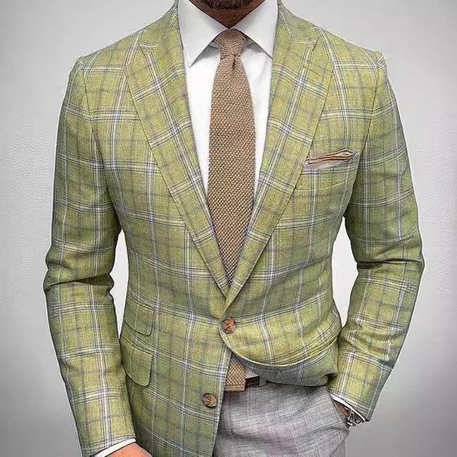 Man wearing green plaid blazer with brown tie, white shirt, gray pants, and pocket square
