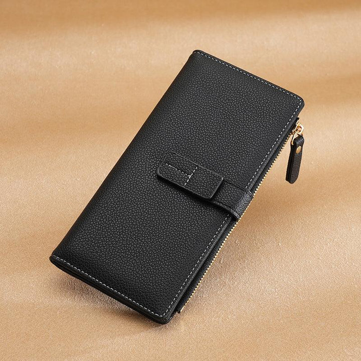 Black textured leather wallet with zipper and strap on beige fabric surface