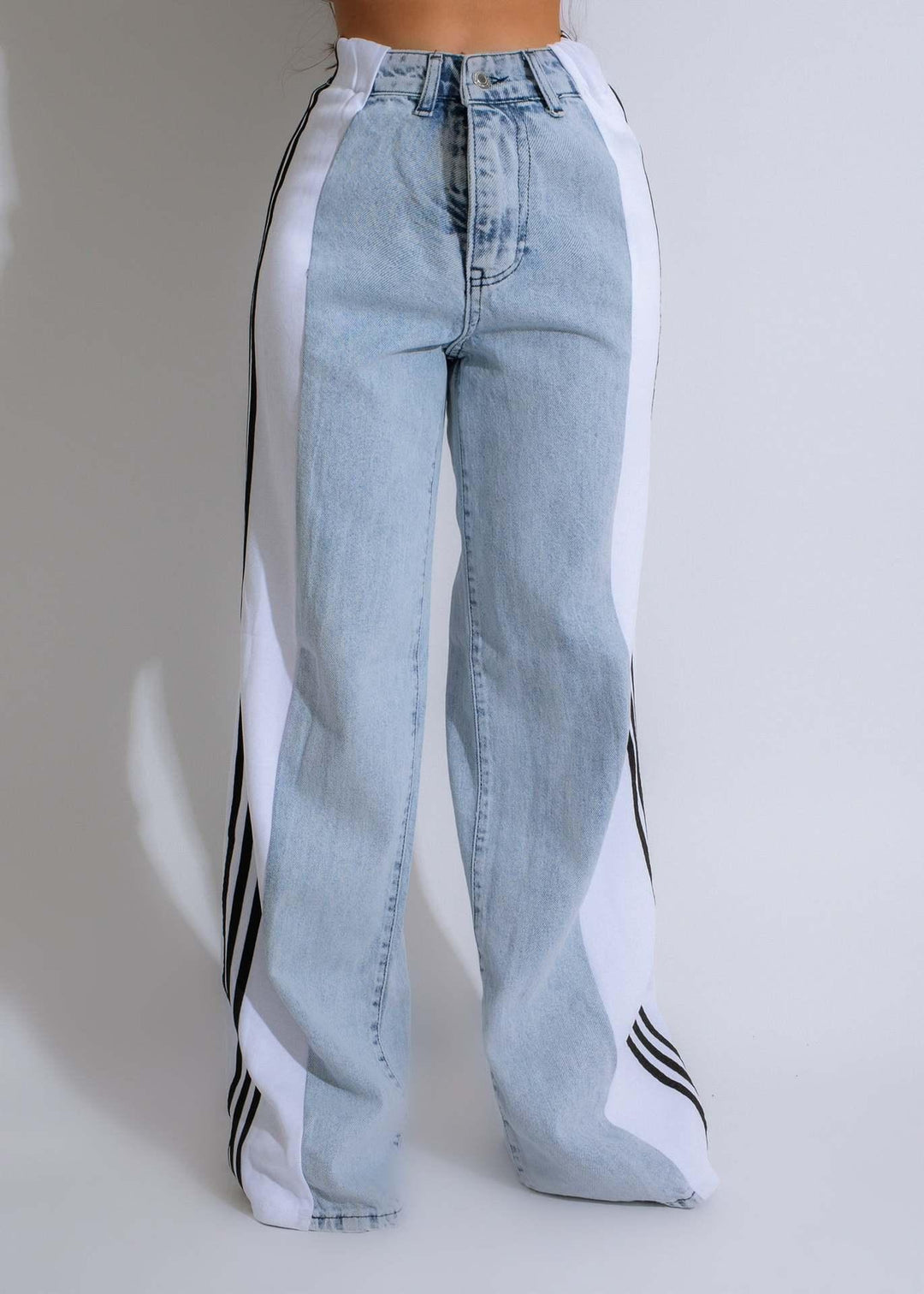 Low-rise light blue denim jeans with wide white side panels and black stripes, straight leg fit