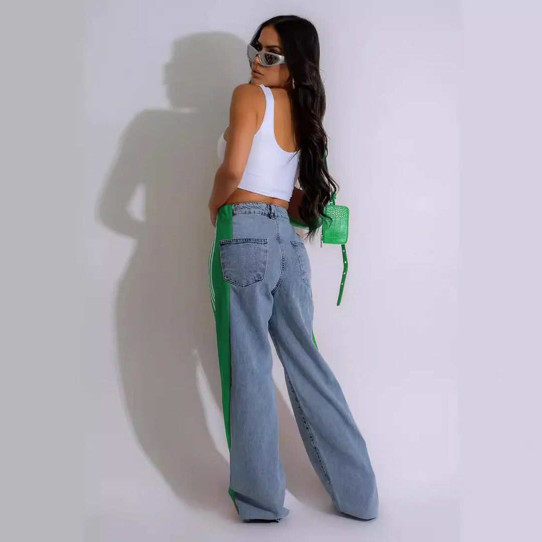Woman wearing white crop top and two-tone green and denim wide-leg pants with green purse and sunglasses