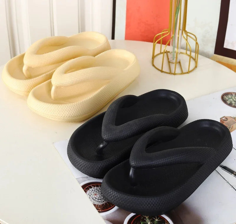 Chunky platform flip flops in beige and black on white table with decorative items