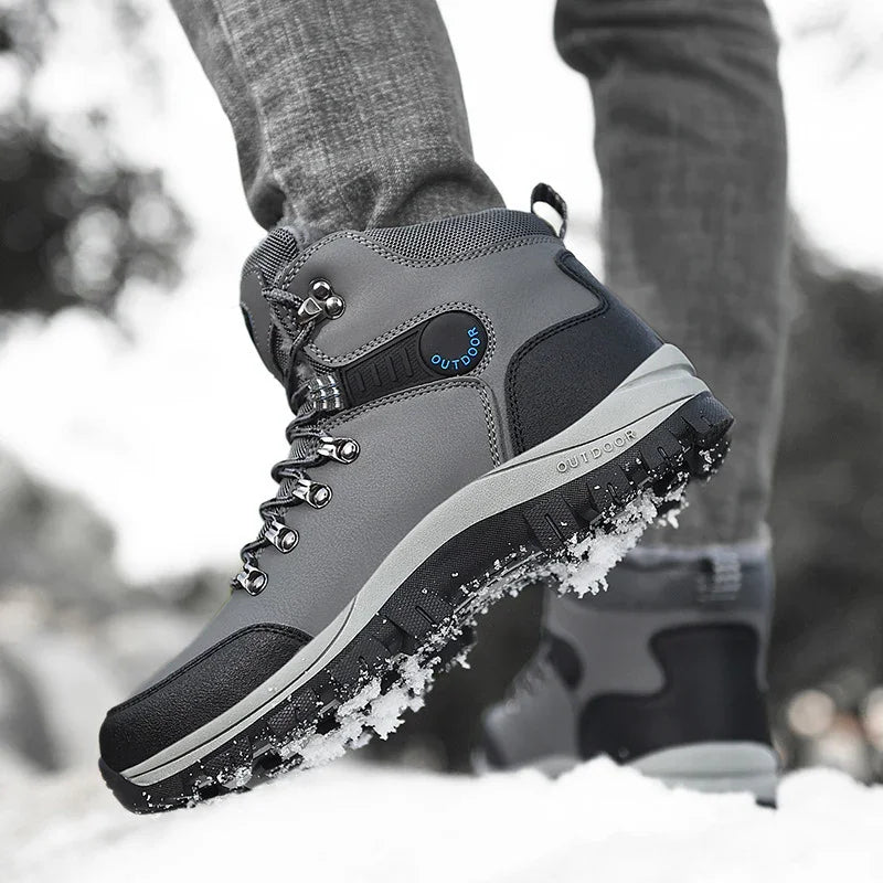 Gray and black outdoor hiking boots with snow-covered soles on snowy ground
