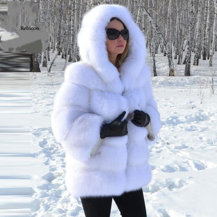 Woman wearing white fur hooded coat and black gloves standing in snowy birch forest