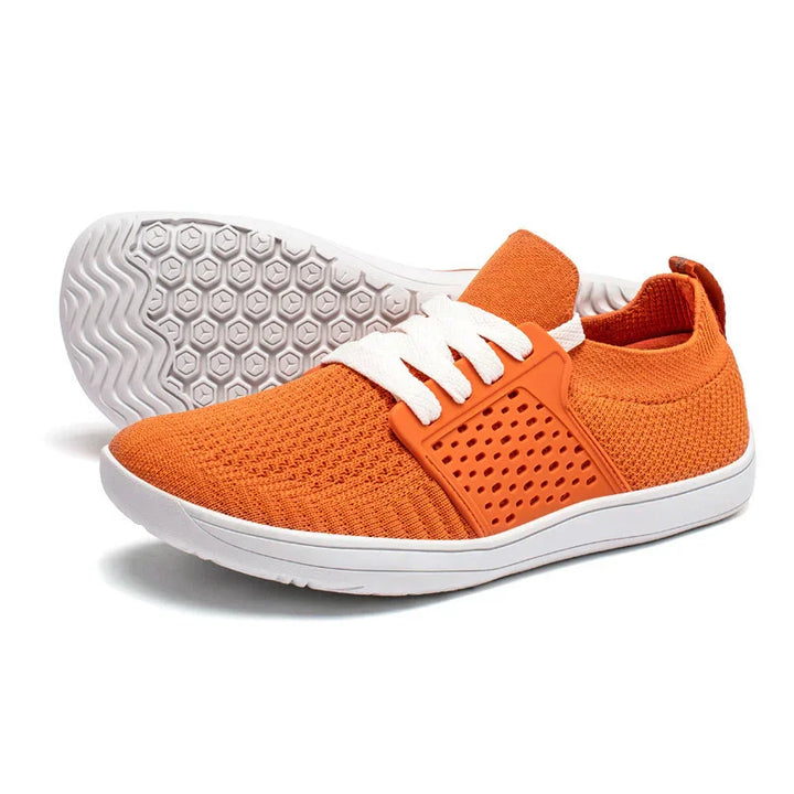 Orange knit athletic shoes with white soles and laces, featuring breathable perforated side panel