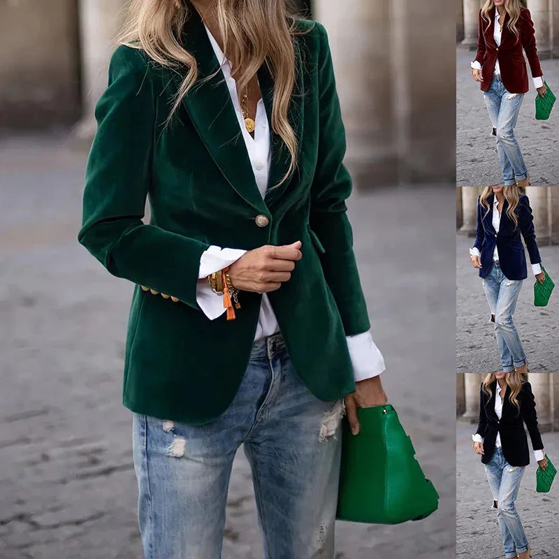 Woman wearing dark green velvet blazer and ripped jeans holding green handbag in urban setting