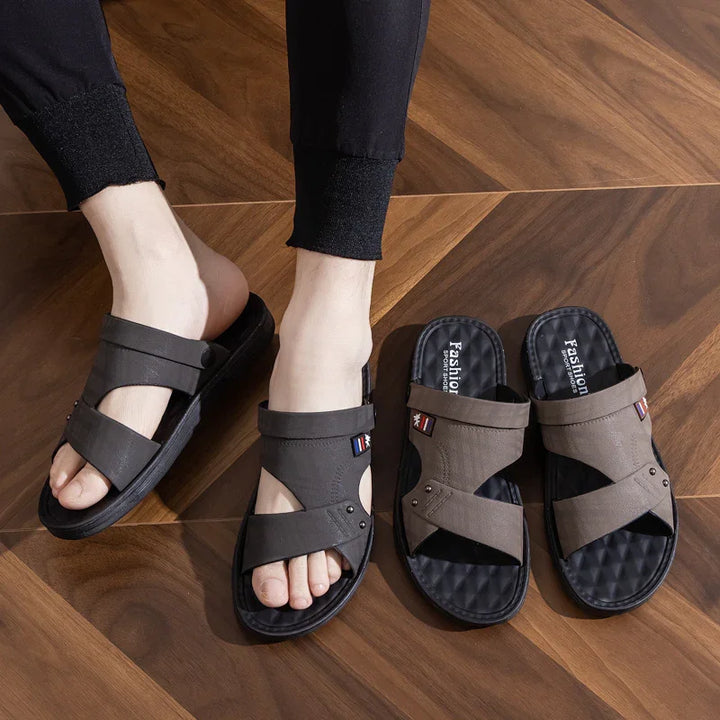 Men's casual brown open-toe sandals on feet and wooden floor with extra pair beside