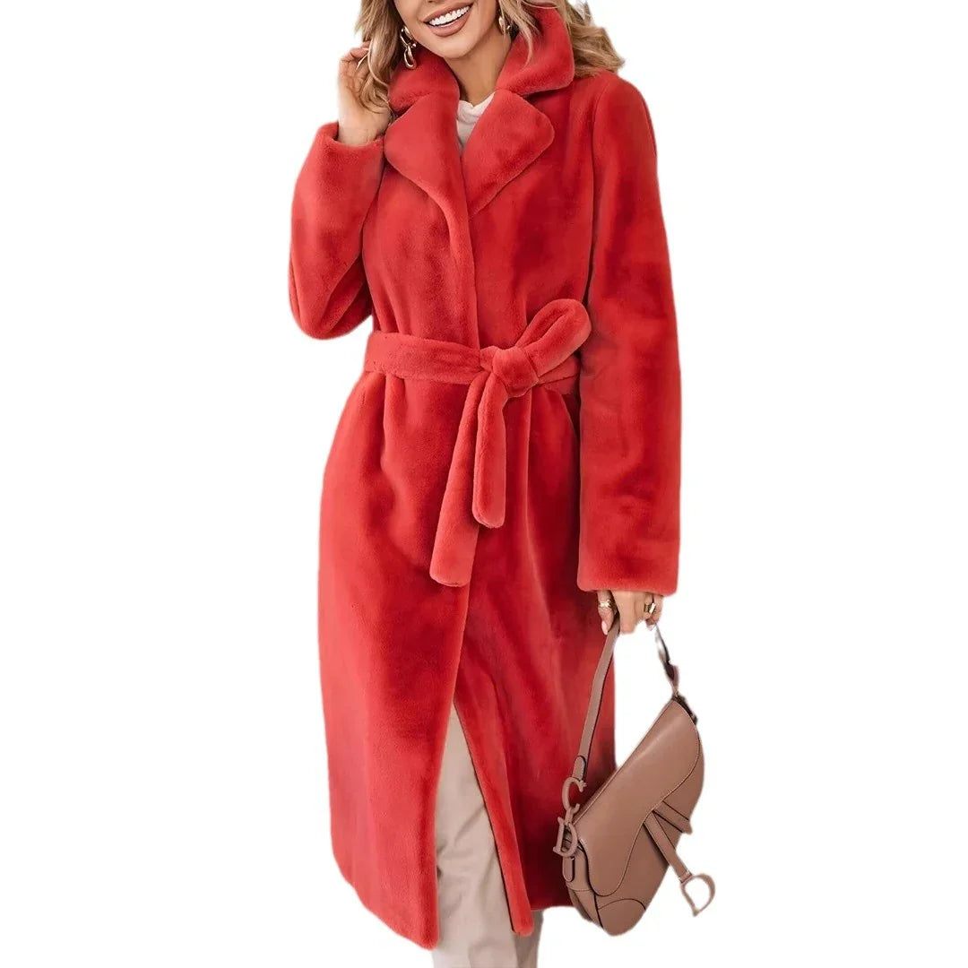 Woman wearing a long red faux fur coat with belt, carrying beige handbag, smiling