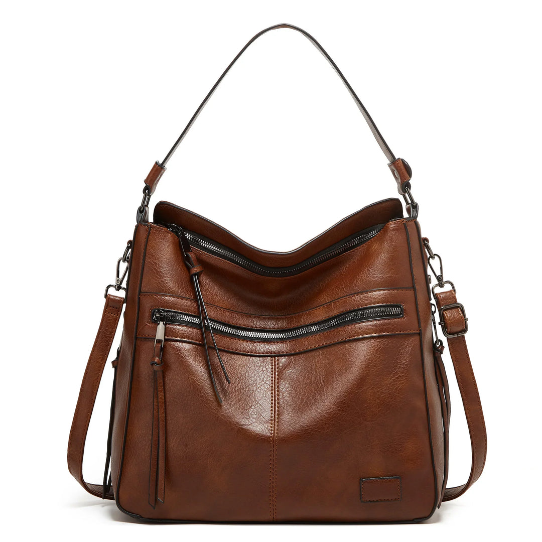 Brown leather handbag with adjustable shoulder strap and front zipper pocket