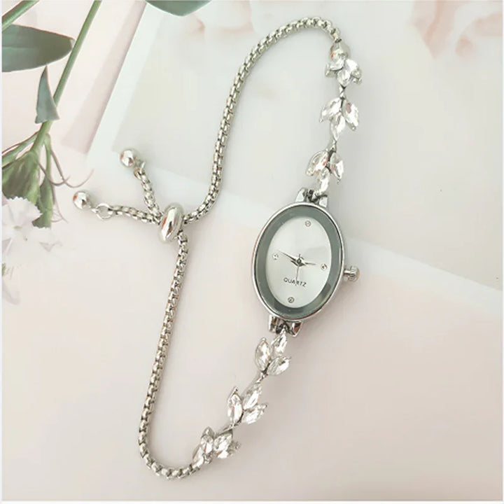 Elegant silver quartz wristwatch with oval face and leaf design chain bracelet