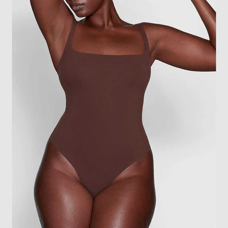 Close-up of a black woman wearing a brown square neckline bodysuit against a gray background