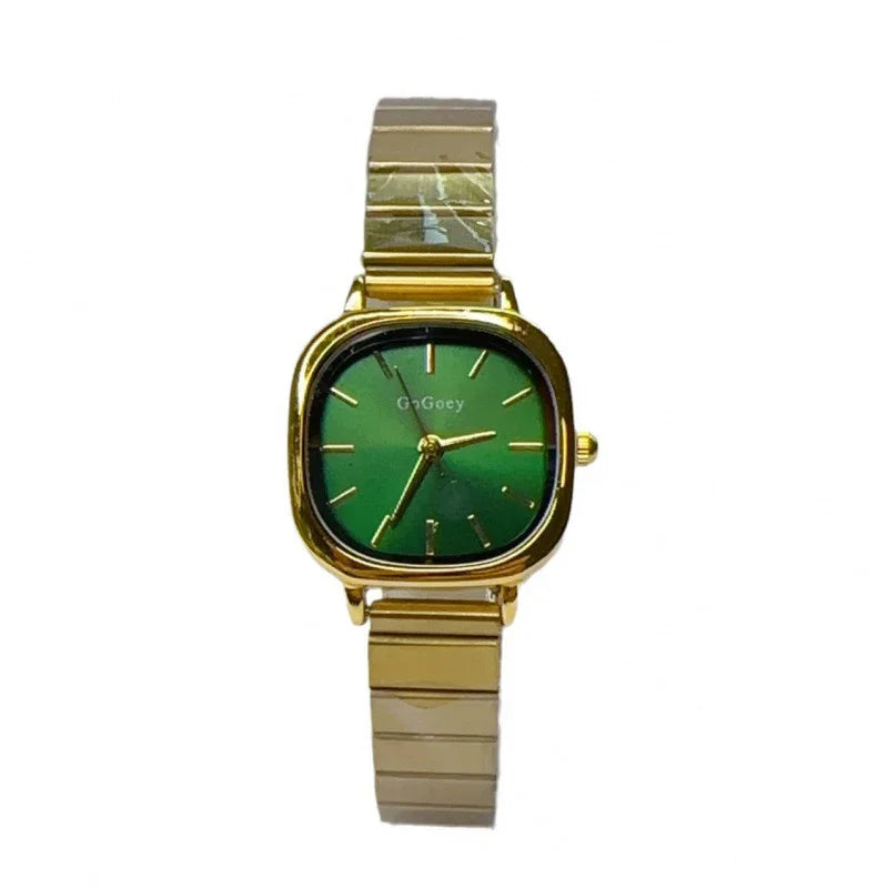Gold wristwatch with green square dial and matching gold metal band on white background