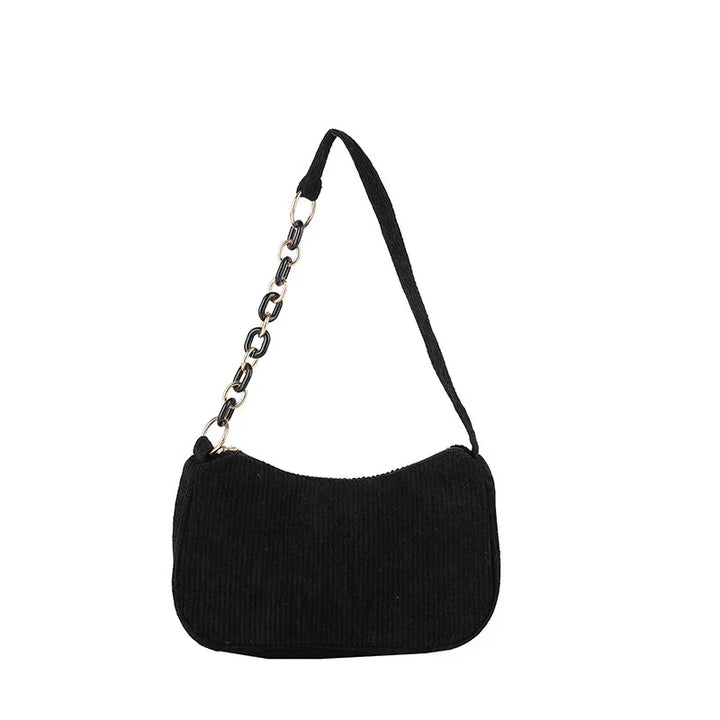Black corduroy shoulder bag with gold and black chain strap on white background
