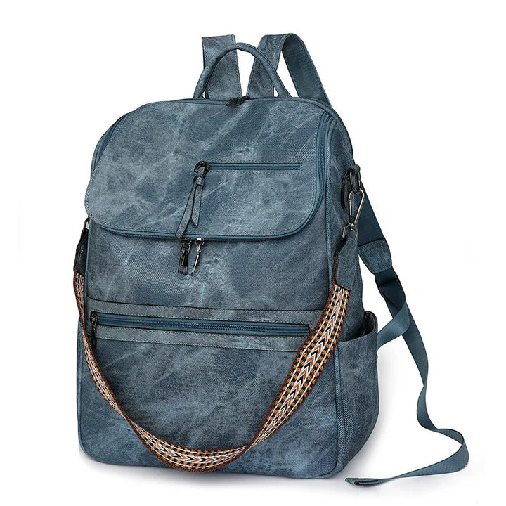 blue canvas backpack with front zipper pockets and patterned shoulder strap