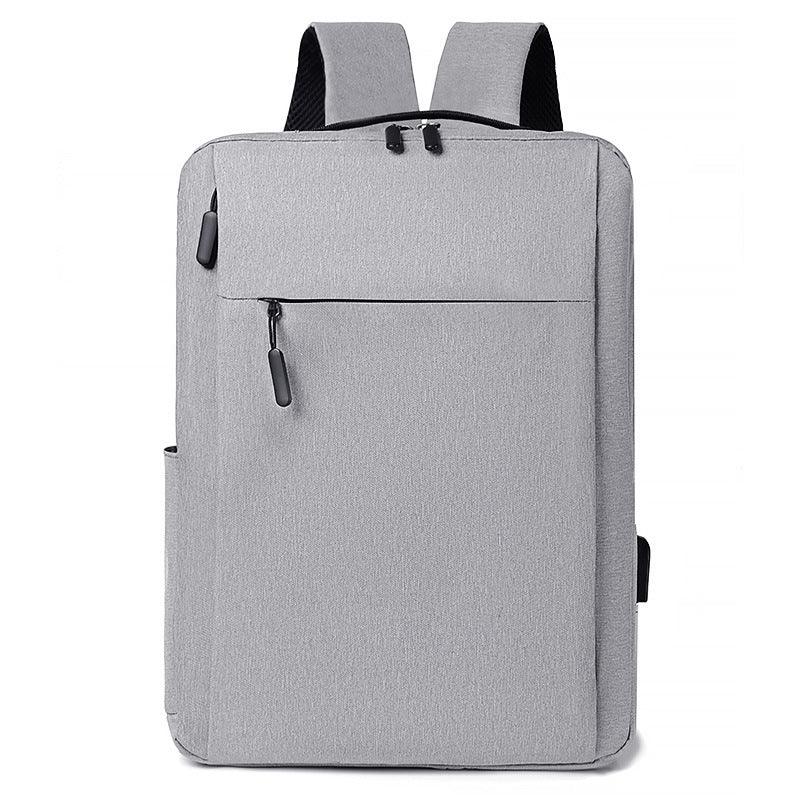 Minimalist light gray rectangular backpack with front zipper pocket and padded shoulder straps