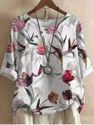 White floral blouse with pink and purple tulip prints, 3/4 sleeves, displayed on a wooden hanger