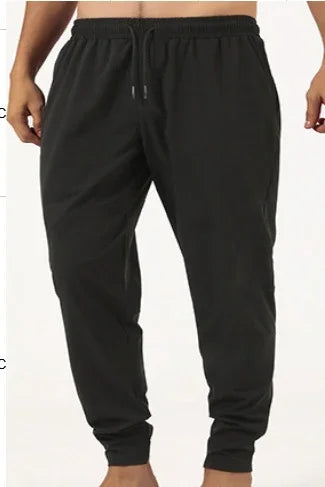 Men's black jogger pants with elastic waist and cuffed ankles on model