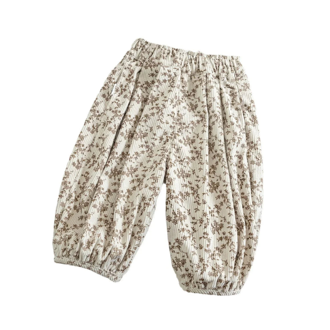 Loose fit kids pants with brown floral print on white fabric and elastic waistband and cuffs