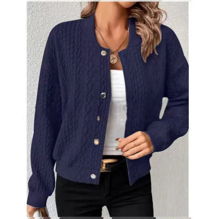 Woman wearing navy blue cable knit button-up cardigan with white top and black pants