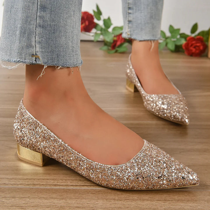 sparkling gold glitter pointed toe low block heel shoes worn with light blue frayed hem jeans on wooden floor