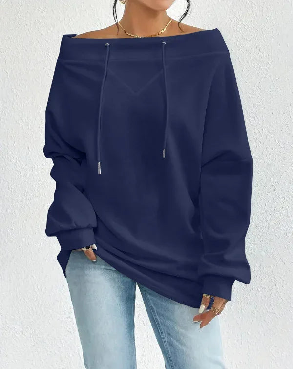 Woman wearing navy off-shoulder casual sweatshirt with drawstrings and light blue jeans