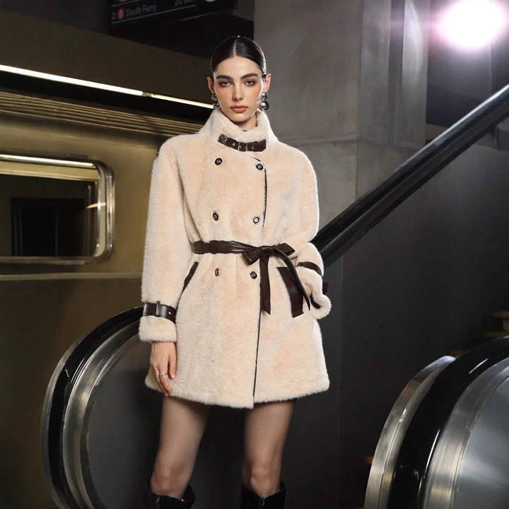 Fashion model in beige faux fur coat with brown leather belt standing by escalator in subway