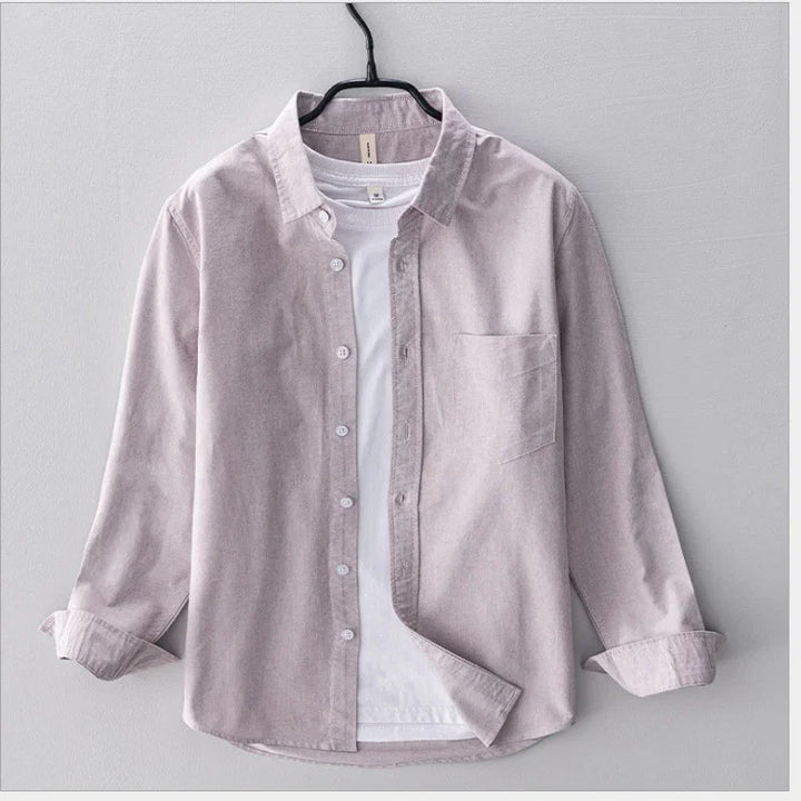 Light purple corduroy shirt with front pocket layered over white t-shirt on hanger