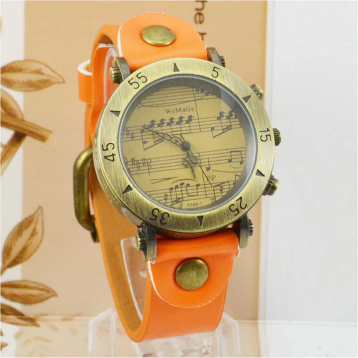 Vintage wristwatch with orange leather strap and brass round bezel featuring music note dial