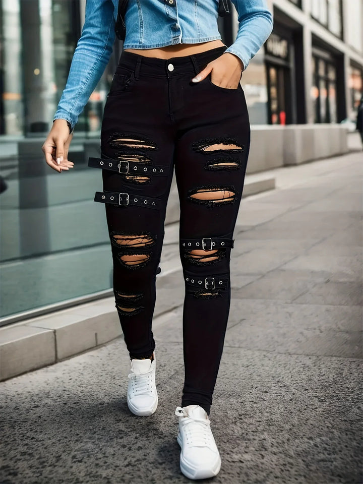 Street style black ripped skinny jeans with buckle straps paired with white sneakers