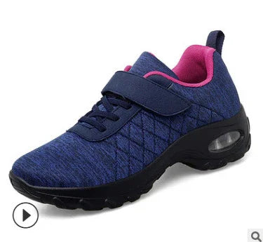Navy blue women's athletic sneaker with pink interior, quilted fabric, velcro strap, and cushioned sole