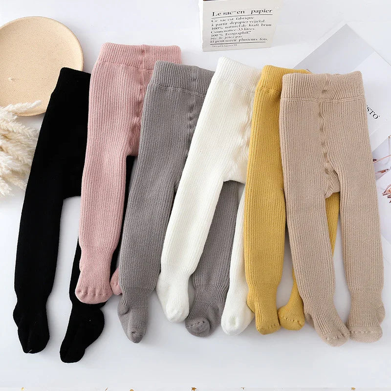 Set of six ribbed knit baby tights in black, pink, gray, white, yellow, and beige on white background